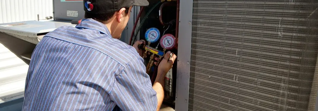 HVAC technician servicing a condenser unit in Fruit Cove